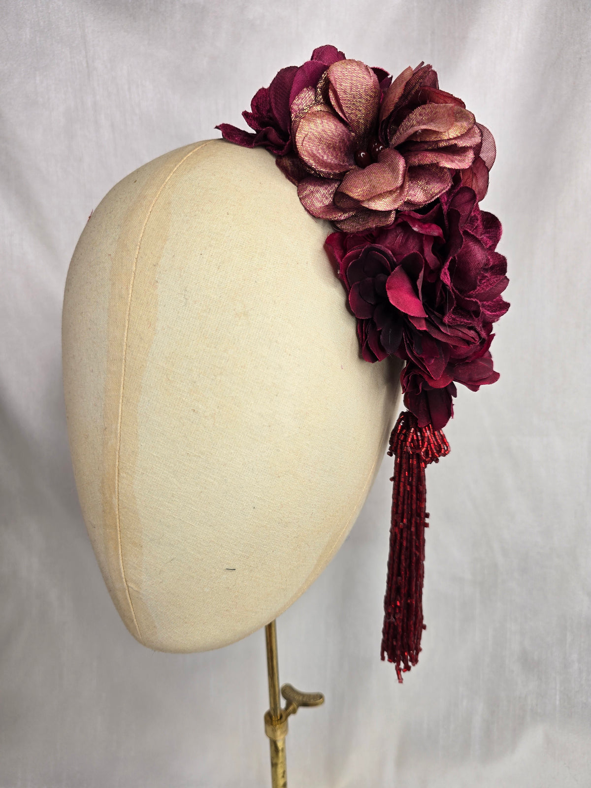 Medium burgundy and maroon flower headpiece/corsage with beaded tassel