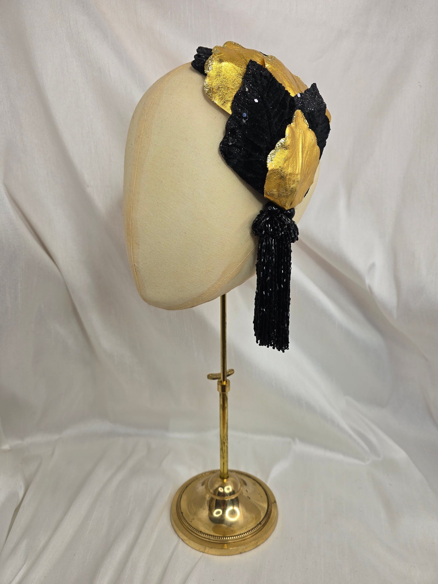 Black and gold glittered half hat/fascinator with beaded tassels