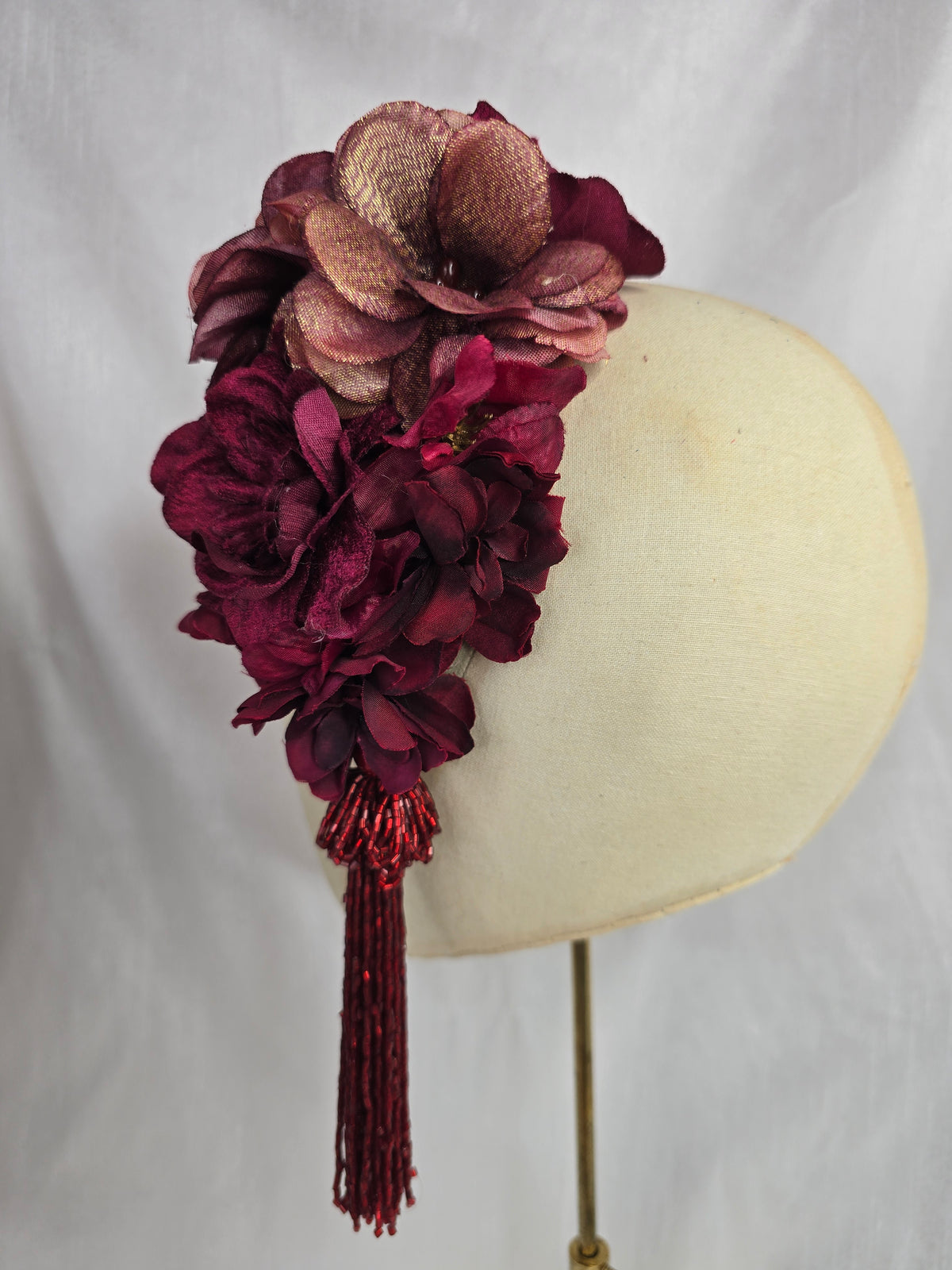 Medium burgundy and maroon flower headpiece/corsage with beaded tassel