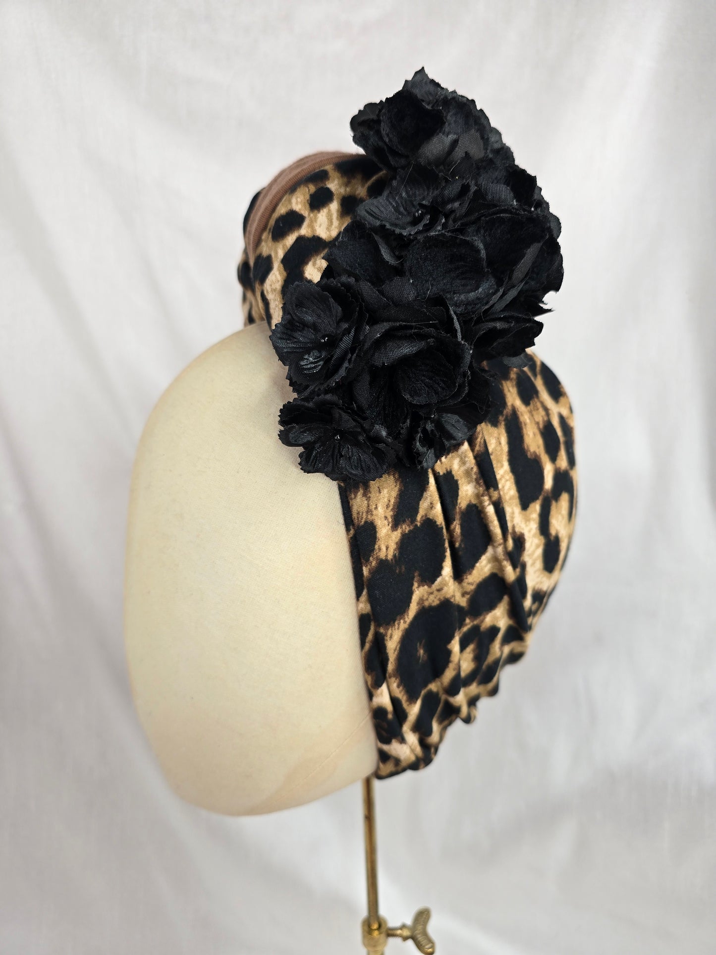Leopard and tan stretch jersey turban with flower trim and corsage