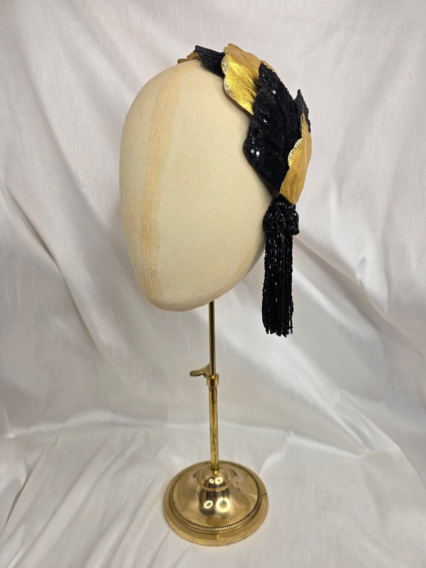 Black and gold glittered half hat/fascinator with beaded tassels